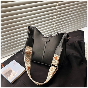 Detail of black leather hobo bucket bag with ethnic geometric wide shoulder strap