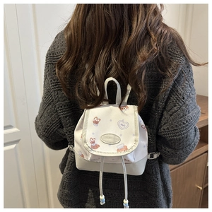 Back view of a mini white PU backpack featuring cute bear prints on a model silhouette