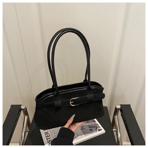 Detail of black suede shoulder bag with dual long handles and gold buckle strap decoration