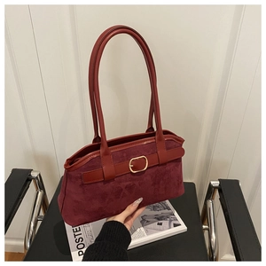 Close-up of vintage burgundy suede underarm bag with elegant golden square buckle