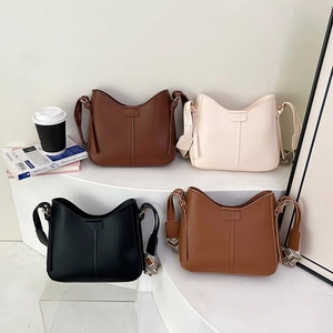 Minimalist half-moon crossbody bags with geometric jacquard straps in four neutral colors