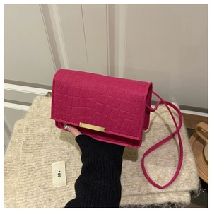 Détail du sac bandoulière rose fuchsia motif crocodile et boucle en métal doré