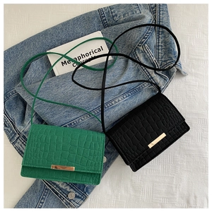 Détail de mini sacs à bandoulière en crocodile vert et noir avec boucles dorées