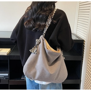 Dettaglio della borsa hobo in velluto a coste grigio con fiocco a righe bianche e nere