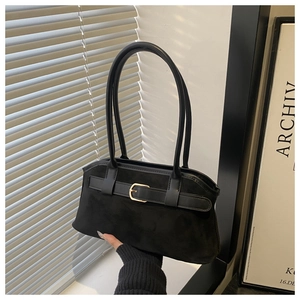 Détail du sac à bandoulière en daim noir avec boucle dorée décorative et poignée élégante