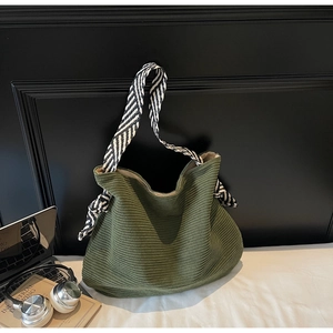 Dettaglio borsa hobo in velluto a coste verde scuro con trama e tracolla intrecciata