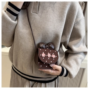 Detailansicht der braunen gepunkteten Mini-Tasche mit rosa Blumen und süßer Schleife