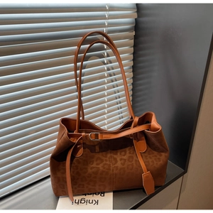 Detail of suede leopard print tote bag with adjustable straps and metal buckles