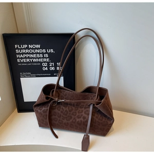Detailed view of large leopard print tote bag with soft suede texture and slim straps