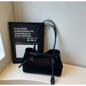 Detail of faux fur leopard print tote bag with silver buckle and black leather shoulder straps