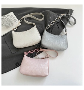 Detailed view of textured striped fabric and chain shoulder strap on trendy underarm bags