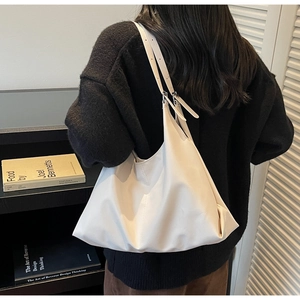 Detail of adjustable double straps on a white minimalist tote bag shown with model