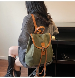 Detail of dark green vintage backpack with brown leather straps and matte texture finish