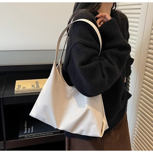 Minimalist cream oversized hobo bag on shoulder with casual winter knitwear outfit