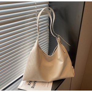 Detail of cream white large capacity tote bag featuring adjustable strap and soft leather texture
