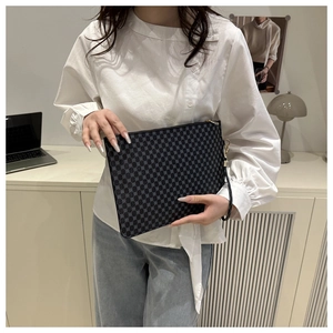 Close-up of black and grey checkered envelope clutch with zipper and hand strap