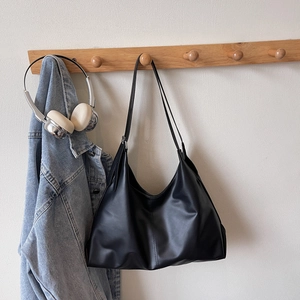Minimalist black matte leather Hobo bag with crescent shape and slim shoulder strap