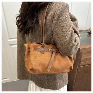 Close-up of brown suede tote bag with belt buckle detail and elegant draping effect