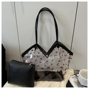 Detail of transparent PVC tote bag with cherry print and black inner leather pouch