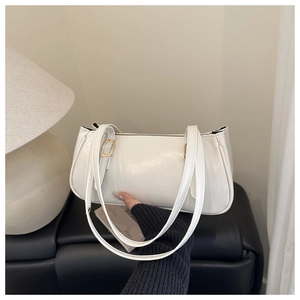 Détail du sac à bandoulière en similicuir blanc crème avec boucle dorée et finition brillante