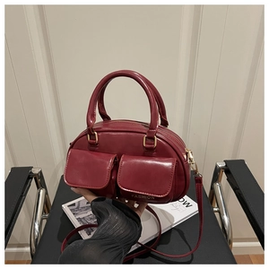 Detailed view of the dark red leather vintage bag with dual front pockets and top handle