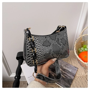 Detail of grey python texture PU leather handbag with chunky black and gold chain strap