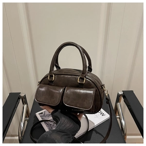 Detailed close-up of dark brown vintage Boston bag with dual flap pockets and gold hardware