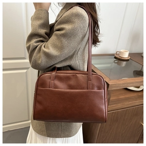 Close-up of a vintage brown PU leather shoulder bag with a functional front pocket detail