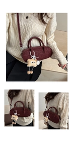 Close-up of vintage burgundy baguette bag with leopard embossing and plush monster charm