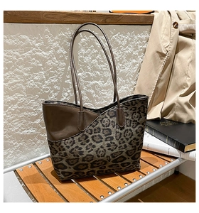 Detail of the leopard print and brown leather stitching on a large commuter tote bag
