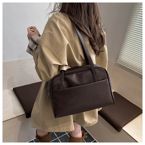 Detail of a large dark brown PU leather tote bag with a practical front pocket design