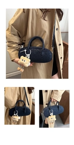 Detail of dark blue leopard print faux suede baguette bag with plush doll charm