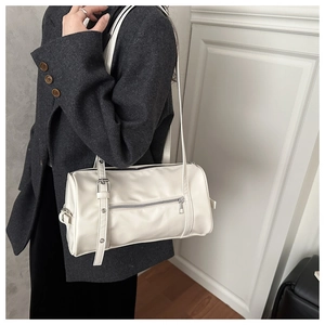 Close-up of white minimalist Boston bag featuring silver hardware on a wool blazer