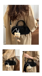 Detail of leopard print suede cylinder bag with fuzzy monster charm and strap