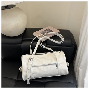 Detail of off-white cylinder shoulder bag with silver hardware and adjustable strap
