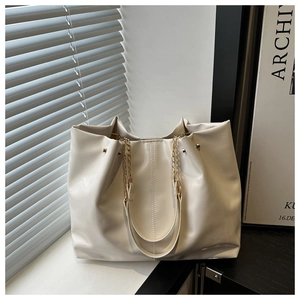 Detail of off-white tote bag featuring pleated texture and gold chain shoulder strap