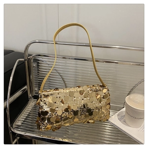 Gros plan d'un sac à bandoulière à paillettes dorées dans un décor de café branché