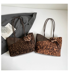 Detail view of leopard print patchwork tote bags with plush heart charms on white background