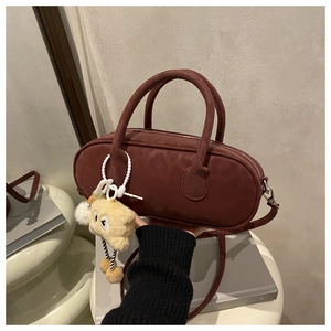 Detail of burgundy faux suede baguette bag with plush toast charm and top handles