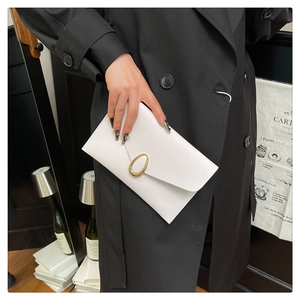 Detail of white envelope clutch featuring lychee texture and gold oval metal buckle