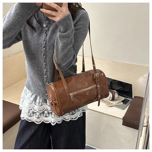 Mirror selfie showing the shiny brown leather Boston bag with silver zipper and strap