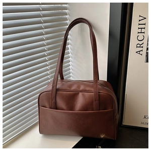 Detailed close-up of brown PU leather shoulder bag with exterior pocket and metal zipper