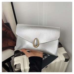 Detail of silver envelope clutch with saffiano texture and golden oval metal lock clasp
