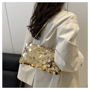 Détail du sac sous l'aisselle à paillettes dorées avec de grands sequins et une bandoulière