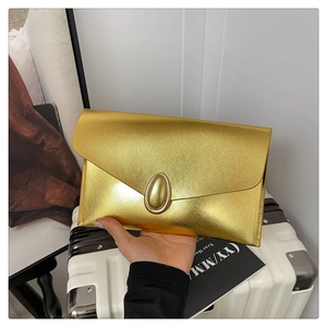 Detail of a gold metallic envelope clutch bag featuring cross-grain texture and oval buckle