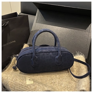 Macro view of navy blue faux suede baguette bag with subtle leopard print and silver hardware