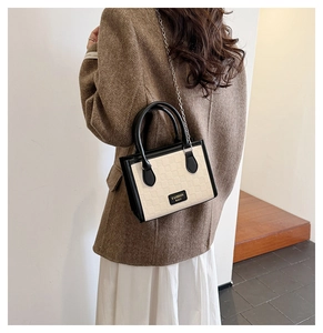 Detail of beige quilted mini crossbody bag worn with a brown herringbone blazer