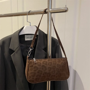 Sac sous le bras imprimé léopard marron en daim avec boucle argentée sur blazer gris élégant