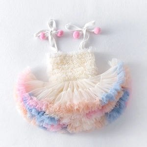 Detail of girls' tutu dress with colorful mesh layers and pink pom-pom shoulder straps