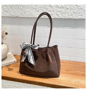 Detailed view of dark coffee suede tote bag featuring an elegant Paris print silk scarf